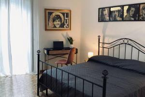 a bedroom with a bed and a desk with a laptop at Palestro 8_Art Holiday House in Caramanico Terme