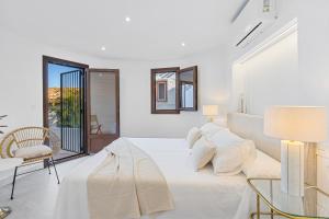 a white bedroom with a bed and a glass table at Comeback LA CASA DEL SOL NACIENTE in Salobreña