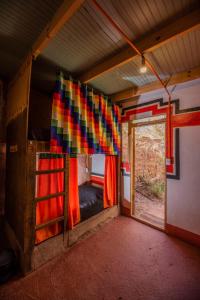 Habitación con cama, ventana y cruz en Casa Voyage Hostel, en San Pedro de Atacama