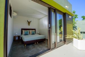 una camera da letto con un letto e porte scorrevoli in vetro di Bohemi Design Villa's a Dorp Sint Michiel