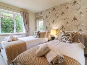 a bedroom with two beds and a wall with birds at Beautiful home with hot tub near Cambridge in Royston