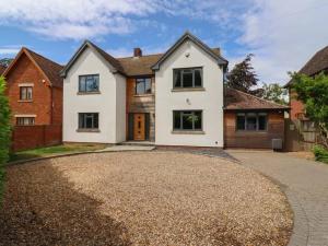 a large white house with a driveway at Beautiful home with hot tub near Cambridge in Royston