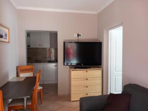 a living room with a flat screen tv on a dresser at Hanna Apartman in Balatonlelle