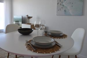 a white dining room table with plates and wine glasses at Studio Zeezicht by Qua-Lyne in Ostend +43 photos