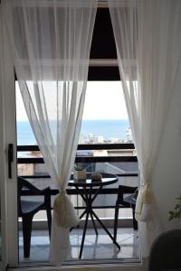 balcone con tavolo e vista sull'oceano di La Casa Blanca a Kavala