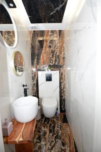 a bathroom with a white toilet and a sink at La Casa Blanca in Kavála