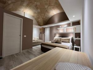 Cette grande chambre comprend deux lits et une table. dans l'établissement AvVolta nel Salento - Room & Relax, à Torchiarolo