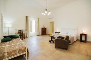 una camera con due letti e un tavolo con sedie di Palazzo Terra d'Otranto a Martano