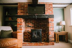 a fireplace with a tv on top of it at Pebbles Cottage in Caister-on-Sea