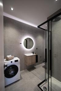 a washing machine in a bathroom with a mirror at Feelin' Good Apartment in Ioannina