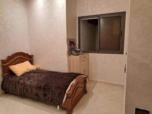 een slaapkamer met een bed, een dressoir en een raam bij Apparemment près de la rivière Sebou in Kenitra