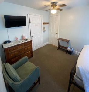 a bedroom with a bed and a chair and a tv at Cherokee Lodge in San Diego