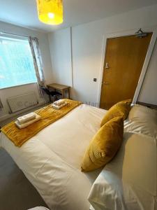 4 bed house, fully equipped & close to amenities. في هال: غرفة نوم بسرير ابيض كبير عليها منشفتين
