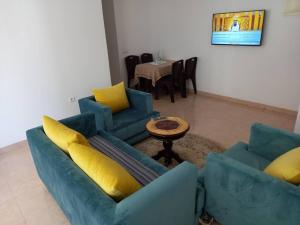 een woonkamer met twee blauwe banken en een tafel bij Appartement Agadir Salam in Agadir