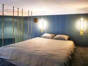 a bedroom with a large white bed with two lights at Butikowy apartament w centrum Warszawy in Warsaw