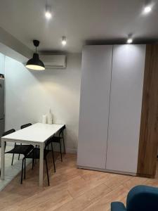 um quarto com uma mesa e cadeiras e uma parede branca em Two-bedroom apartment em Bishkek