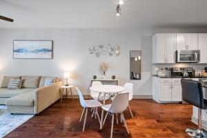 uma cozinha e uma sala de estar com mesa e cadeiras em Comfy Retreat Balcony Views Amenities em Woodbridge