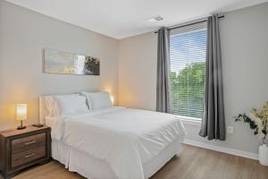 a bedroom with a white bed and a window at Cityscape Haven Views Close to DC in Arlington