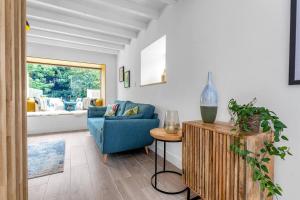 a living room with a blue couch and a table at Luxury Riverside Retreat in Broughton