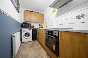 uma cozinha com uma máquina de lavar roupa e uma máquina de lavar roupa em Private retreat for 3 Near Arndale City Centre em Manchester