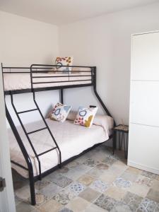 Letto a castello nero con due cuscini sopra di Casa en l'Ampolla, patio y bbq, cerca de la playa, Pet Friendly a L'Ampolla