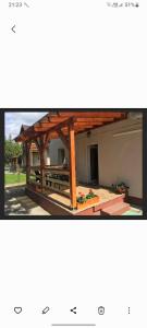 a wooden pavilion with a table in front of a building at Hanna Apartman in Balatonlelle