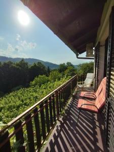 a balcony with chairs and a view of the mountains at Mini hiška v objemu vinograda in Pristava pri Mestinju