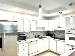 a white kitchen with white cabinets and appliances at Sunny Isles Miami HOLIDAY apartment in Miami Beach