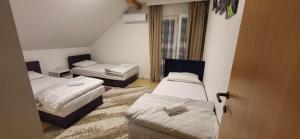 a small room with three beds and a window at Apartments Amina Sarajevo in Sarajevo