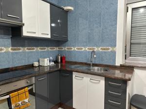 - une cuisine avec des placards blancs et un évier dans l'établissement Piso ceferino, à Barreiros