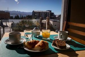 a table with two plates of pastries and cups of coffee at Hotel 7 Lagos in San Carlos de Bariloche