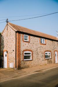 un bâtiment en briques avec trois fenêtres sur une rue dans l'établissement Pebbles Cottage, à Caister-on-Sea