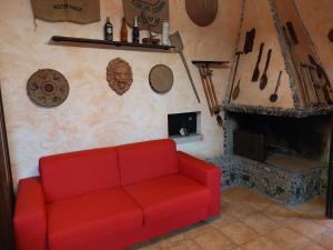 a red couch in a living room with a fireplace at Villa Anna in Flussio