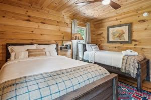 1 dormitorio con 2 camas en una cabaña de madera en Lake Lure Cabin Rental with Private Outdoor Oasis!, en Lake Lure