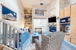 uma sala de estar com uma escada, um sofá e uma televisão em Elkhorn Studio Condo - The Clocktower em Sun Valley