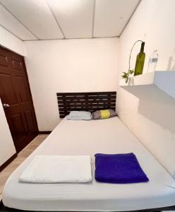 a small room with a bed and a bottle of wine at 8 Habitaciones in Managua