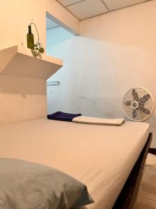 a room with a bed with a fan on it at 8 Habitaciones in Managua