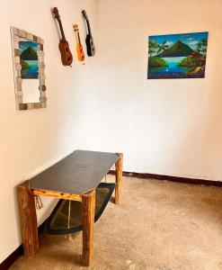 a ping pong table in a room with guitars on the wall at 8 Habitaciones in Managua