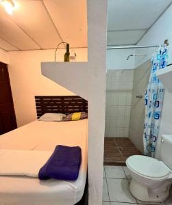 a bedroom with a bed and a shower and a toilet at 8 Habitaciones in Managua