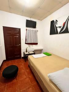 a room with two beds and a tv on the wall at 8 Habitaciones in Managua