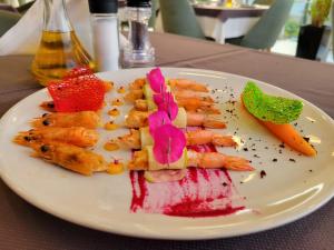 a white plate with food on a table at Blue Water Hotel Ksamil in Ksamil