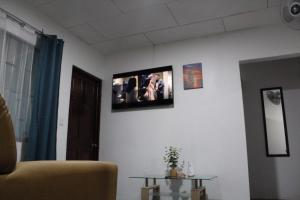 salon z telewizorem na białej ścianie w obiekcie Casa Chu en Playa Manuel Antonio w mieście Manuel Antonio