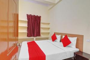 a bedroom with a bed with red pillows and a door at 80983G RBS Square Langer Houz in Haidar Sāhibgūda