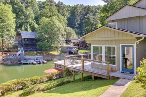 a house with a deck next to a body of water at Waterfront Home with Dock Access on Lake Lure! in Lake Lure