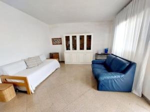 1 dormitorio con 1 cama y 1 sofá azul en apartment Grace, just 200 meter from beach, Campomarino Madonnina, en Torre Ovo