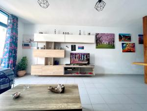 a living room with a flat screen tv on the wall at Casita Mara! 2’ Line to the sea, shops and bar’s in Tías