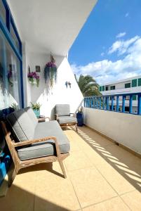 a balcony with a couch and chairs on a building at Casita Mara! 2’ Line to the sea, shops and bar’s in Puerto del Carmen