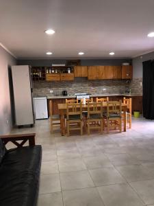 a kitchen with a table and chairs and a refrigerator at El Quincho in Lobos