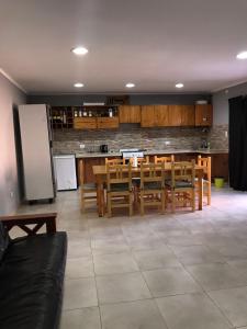 uma cozinha com uma mesa e cadeiras e um frigorífico em El Quincho em Lobos