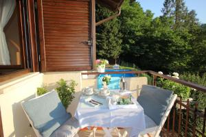 einen Tisch und zwei Stühle auf dem Balkon in der Unterkunft Serenity Escapes - Caldonazzo Lake in Tenna
